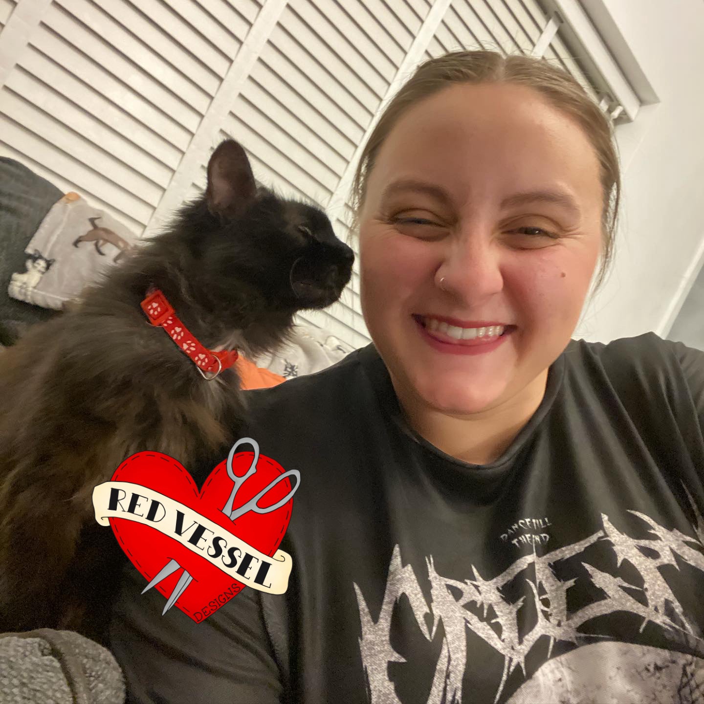 red vessel designs business owner. Woman with a cat on her shoulder, wearing a black t-shirt. 